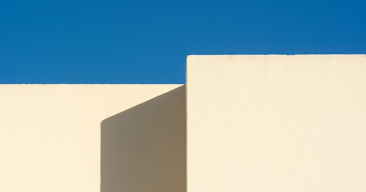 A plain white building against a blue sky